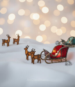Stained glass display with elegant red sleigh in foreground and green sleigh in the background.