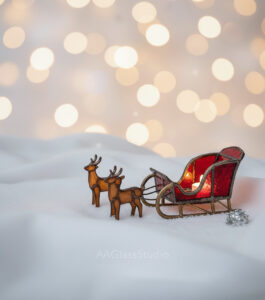 stained glass display of a beautiful stained glass sleigh photographed against a festive, softly lit background.