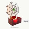 Spooky spider web stained glass candle holder with a green cabochon spider on a white background