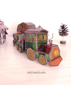 3D stained glass locomotive built from the pattern, standing in a stained glass Christmas village with a small pine tree
