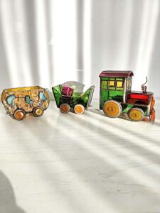 Complete 3D stained glass Christmas train with a green locomotive and three decorated wagons standing together in sunlight