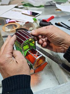 The curved stained glass roof fitted onto the cab of the green 3D stained glass toy locomotive